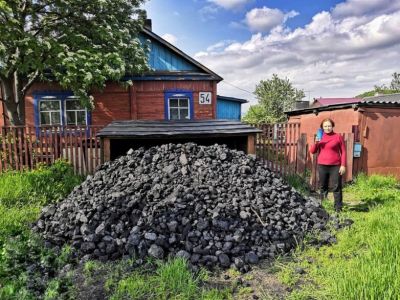 Женщина из Кемеровской области стоит рядом с кучей угля. Фото: пресс-служба "Кузбассразрезугля"
