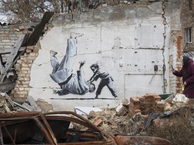 Бородянка. На граффити ребенок побеждает в спарринге мужчину в форме для восточных единоборств. Фото: Andrew Kravchenko / AP